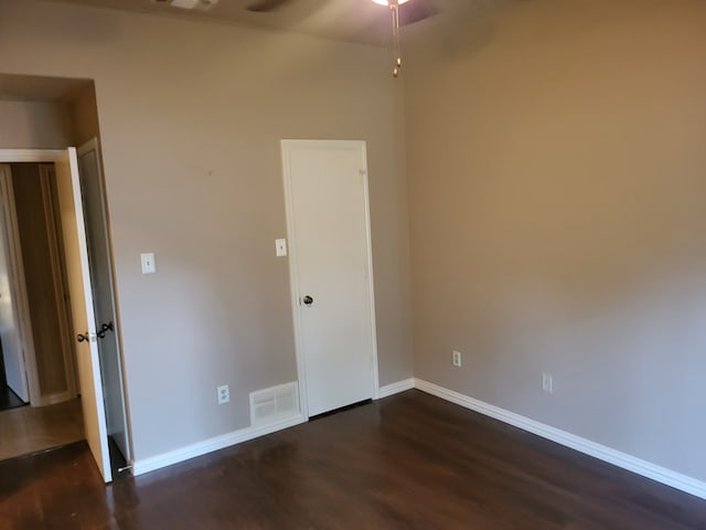 empty room with ceiling fan and dark hardwood / wood-style flooring