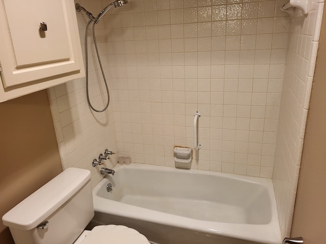 bathroom with tiled shower / bath combo and toilet