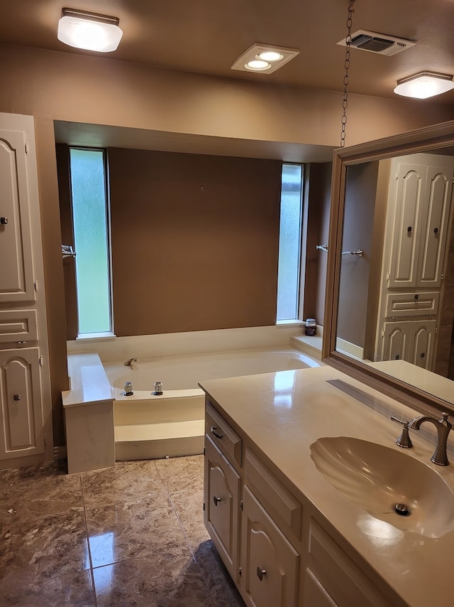 bathroom featuring vanity, plenty of natural light, and a bathtub