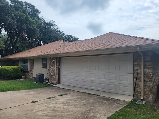 view of front of home with a garage and central air condition unit