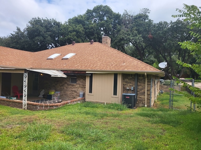 back of property featuring a lawn, central AC, and a patio area