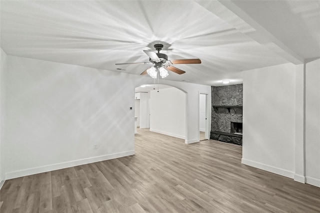 unfurnished living room featuring ceiling fan, a fireplace, and light hardwood / wood-style floors