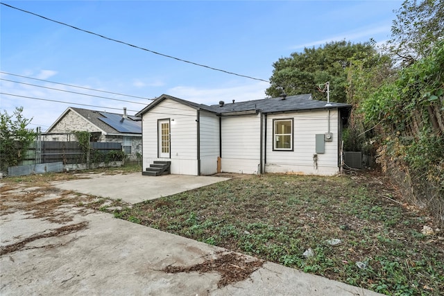 back of property with central AC unit and a patio