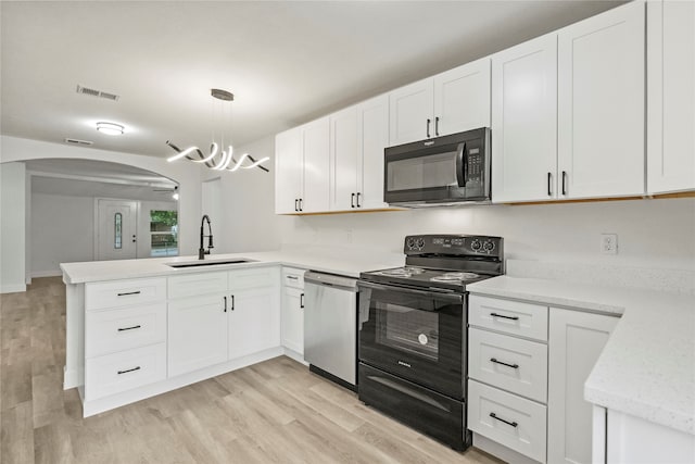 kitchen with black appliances, light hardwood / wood-style floors, hanging light fixtures, kitchen peninsula, and sink