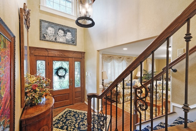 foyer entrance featuring a chandelier, hardwood / wood-style floors, and a high ceiling