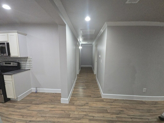 corridor with dark hardwood / wood-style floors and crown molding