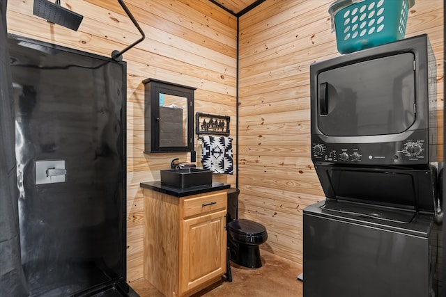 interior space featuring wood walls and stacked washing maching and dryer