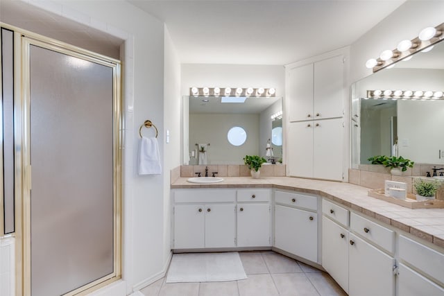 bathroom featuring vanity, a shower with shower door, and tile patterned flooring