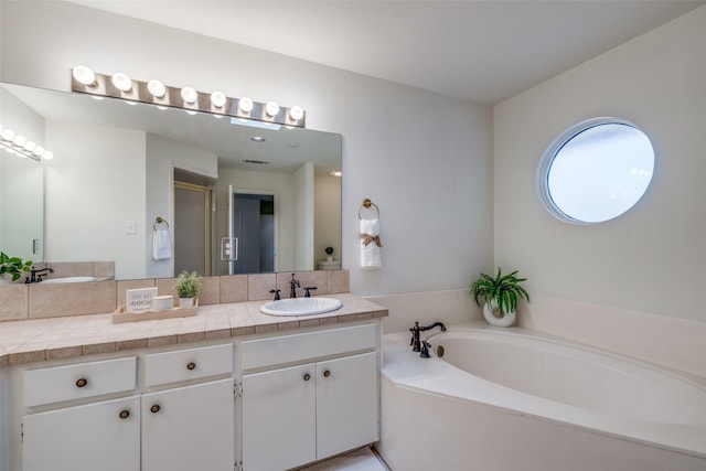 bathroom with vanity and separate shower and tub