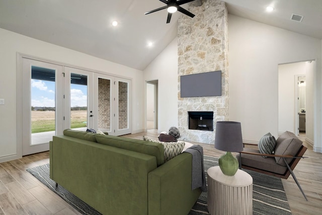 living room featuring high vaulted ceiling, ceiling fan, and a fireplace