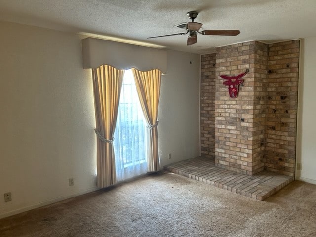 spare room with a textured ceiling, ceiling fan, and carpet