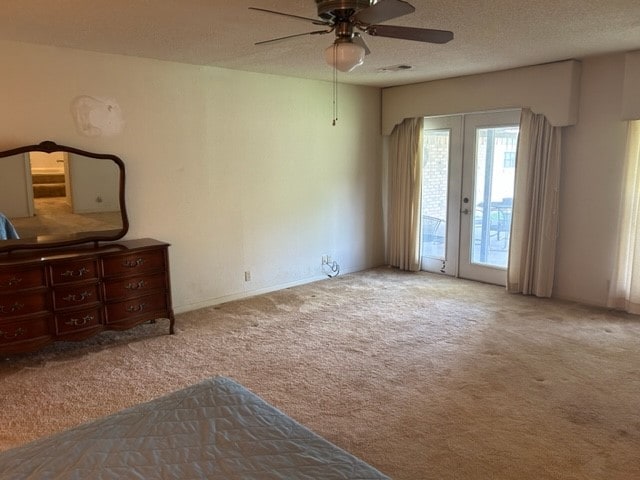 bedroom with a textured ceiling, ceiling fan, light carpet, and access to outside