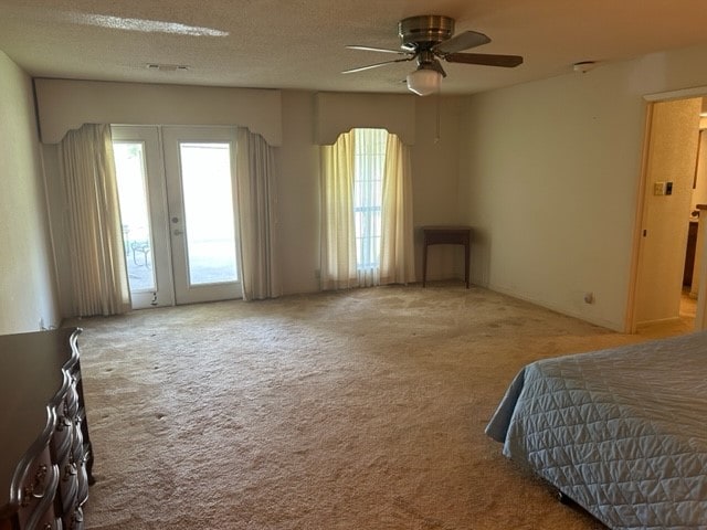 bedroom with french doors, light carpet, access to outside, ceiling fan, and a textured ceiling