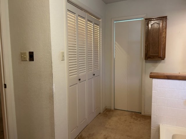 hallway with light colored carpet