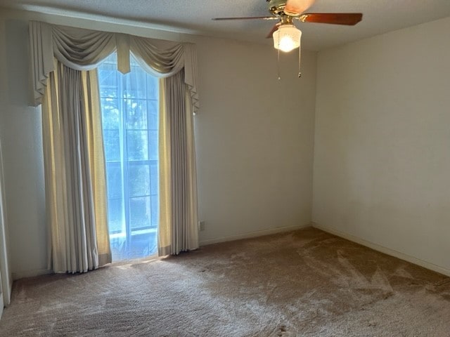 empty room with ceiling fan and carpet