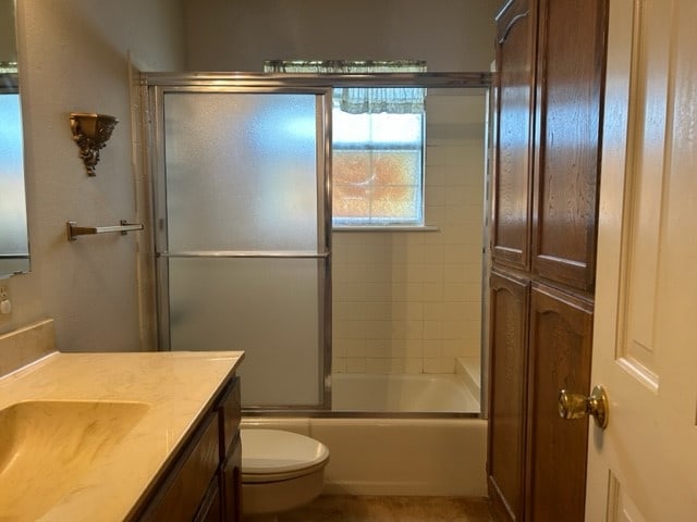 full bathroom with vanity, toilet, and enclosed tub / shower combo