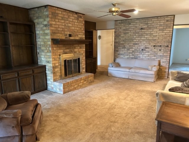 carpeted living room featuring ceiling fan and a brick fireplace