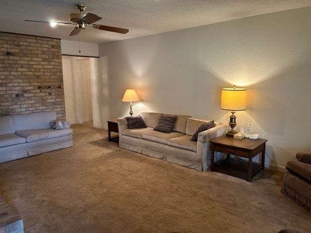 living room featuring carpet flooring, ceiling fan, and a textured ceiling