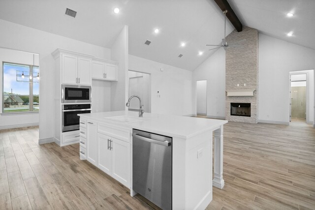 kitchen with light wood finished floors, visible vents, appliances with stainless steel finishes, white cabinets, and a sink