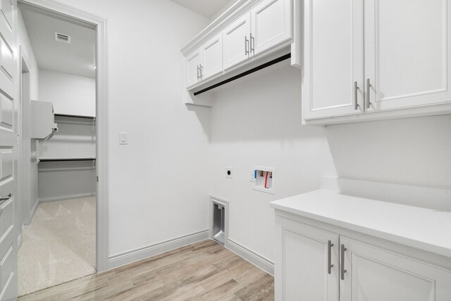 laundry room with washer hookup, visible vents, cabinet space, light wood-style flooring, and electric dryer hookup