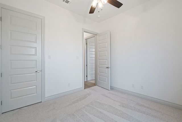 unfurnished bedroom featuring a ceiling fan, carpet, visible vents, and baseboards