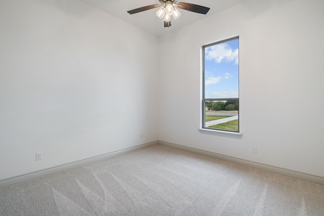 spare room with light carpet, baseboards, and a ceiling fan