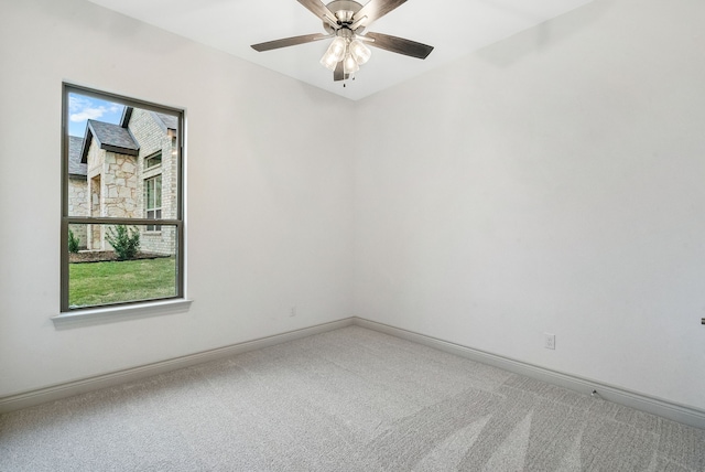 carpeted empty room with a ceiling fan, plenty of natural light, and baseboards