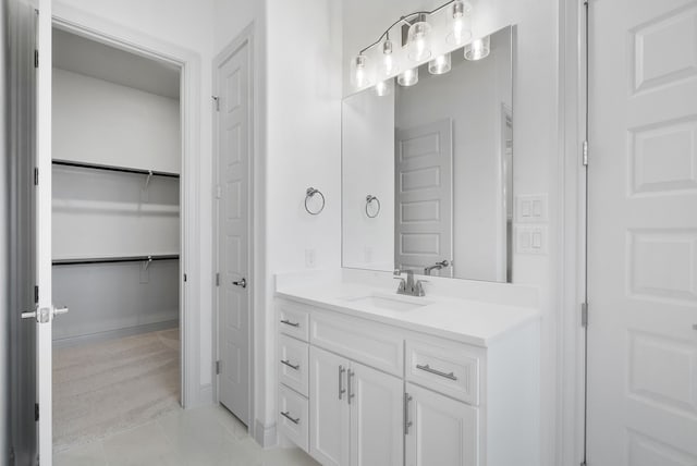 bathroom featuring tile patterned flooring, vanity, and a spacious closet