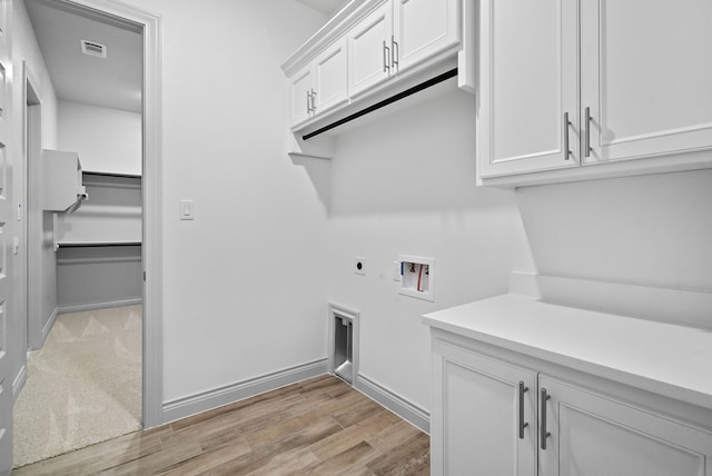 laundry room featuring cabinet space, baseboards, light wood-style floors, washer hookup, and electric dryer hookup