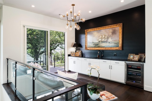 dining space featuring wine cooler, sink, dark hardwood / wood-style flooring, and a chandelier