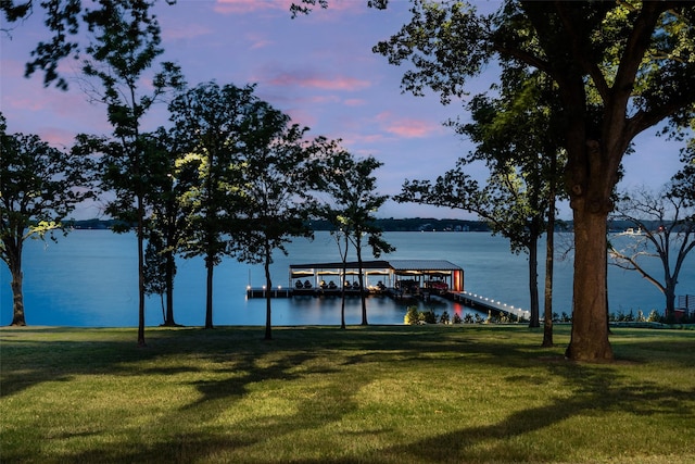 dock area with a water view and a lawn