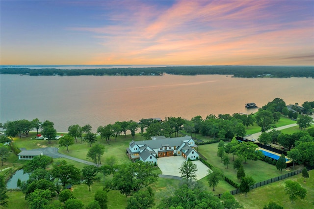 aerial view at dusk featuring a water view