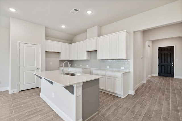 kitchen featuring a center island with sink, light wood-type flooring, white cabinetry, and sink