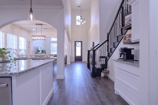 foyer entrance with a notable chandelier and dark hardwood / wood-style flooring