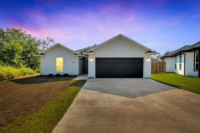 single story home with a lawn, an attached garage, fence, and driveway