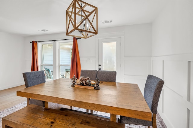 dining area featuring baseboards, wood finished floors, and visible vents
