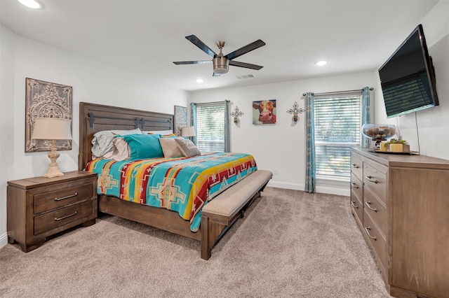 carpeted bedroom featuring multiple windows and ceiling fan