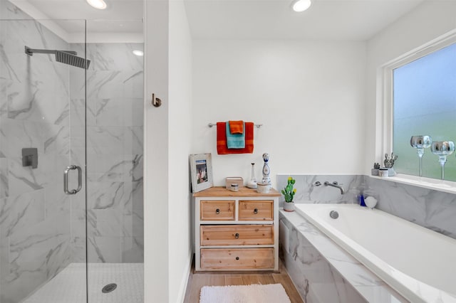 full bathroom with recessed lighting, a marble finish shower, a bath, and wood finished floors