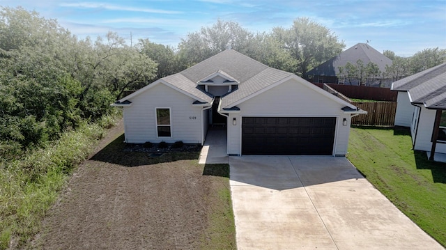 single story home featuring fence, an attached garage, concrete driveway, and a front lawn