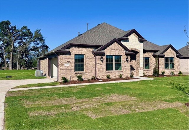 view of front of property with central AC and a front lawn