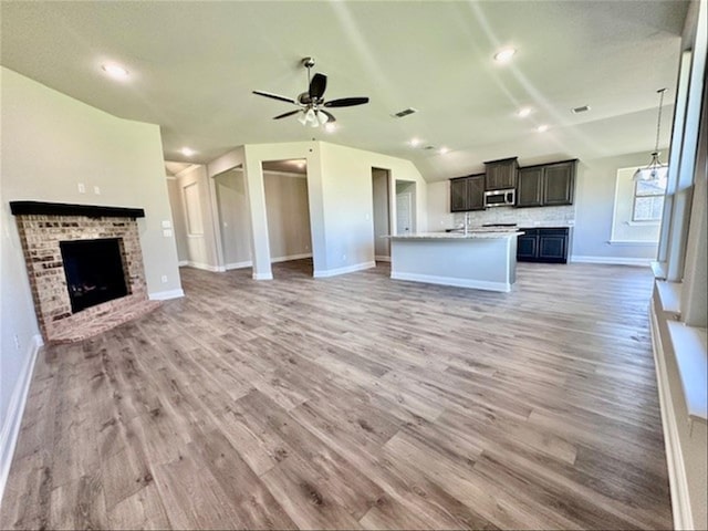 unfurnished living room with a fireplace, light wood-type flooring, and ceiling fan