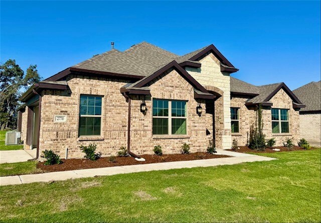 view of front of house with cooling unit and a front lawn