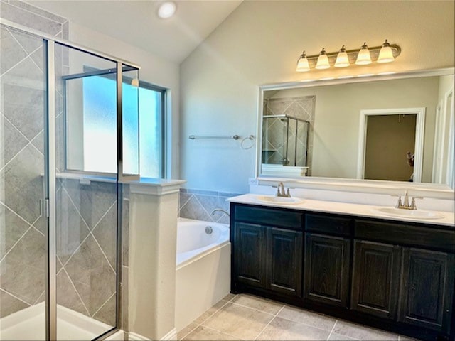 bathroom featuring tile patterned flooring, vanity, independent shower and bath, and vaulted ceiling