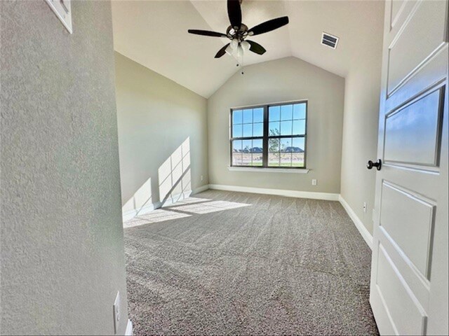 unfurnished room featuring ceiling fan, carpet, and vaulted ceiling