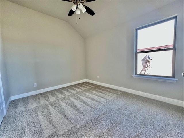 carpeted spare room with ceiling fan and vaulted ceiling