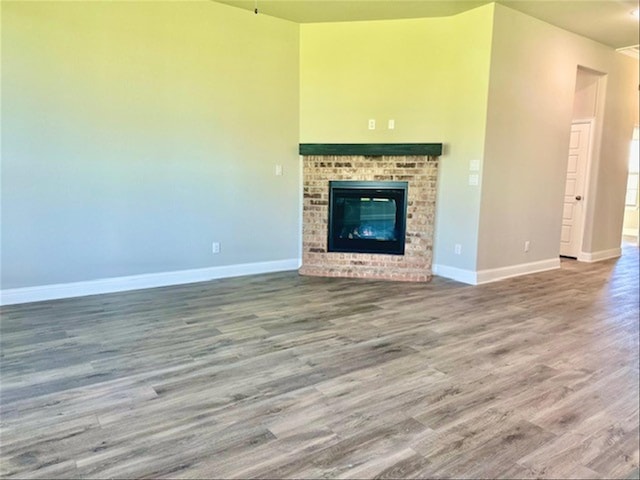 unfurnished living room featuring a fireplace and wood-type flooring