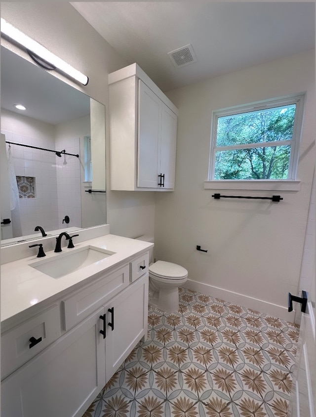 bathroom with vanity, toilet, and a tile shower