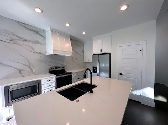 kitchen featuring white cabinetry, custom range hood, a kitchen island, and stainless steel appliances