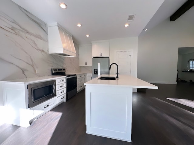 kitchen featuring a kitchen island with sink, white cabinetry, premium range hood, sink, and appliances with stainless steel finishes