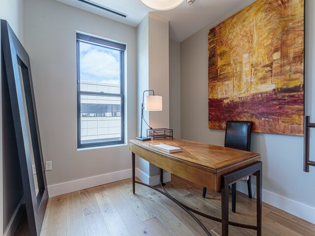 home office with light hardwood / wood-style floors